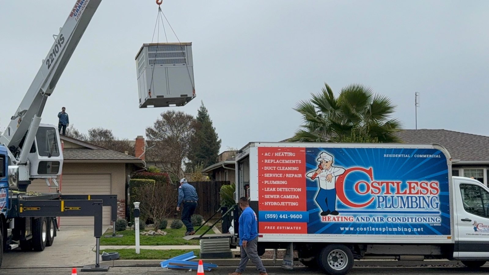 Crane lifting a rooftop HVAC unit